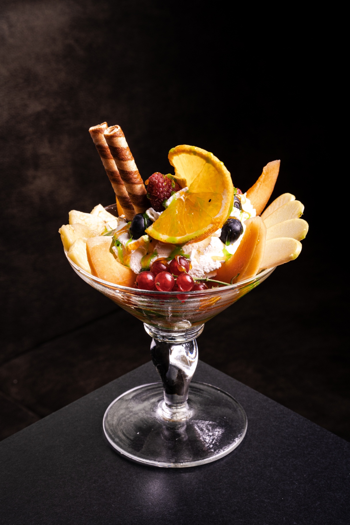 Fruchtbecher mit frischen Früchten, Sahne und Waffel